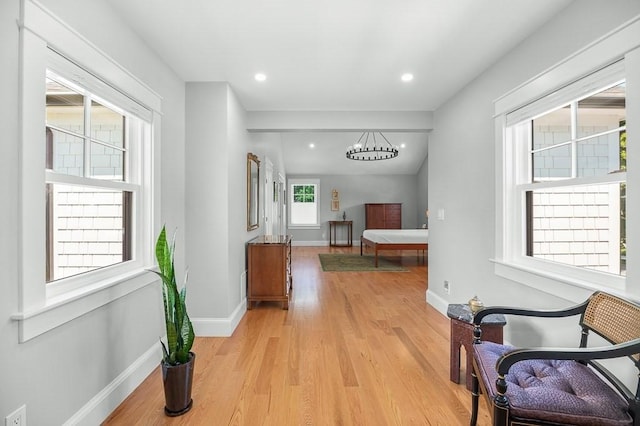 hall featuring a notable chandelier and light hardwood / wood-style flooring