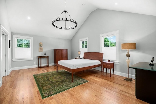 bedroom featuring multiple windows, wood-type flooring, and a notable chandelier