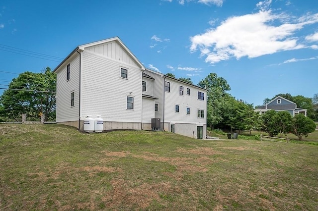 back of house featuring a yard and central air condition unit