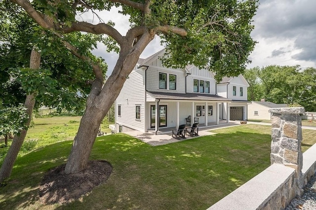 back of house with a garage and a lawn