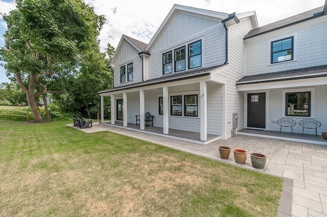 rear view of house with a yard and covered porch