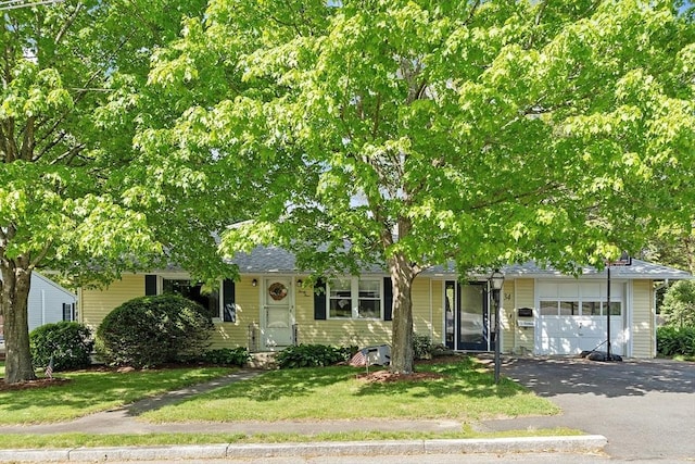 34 Woodland Cir, Methuen, MA 01844 - obstructed view of property featuring an attached garage, asphalt driveway, and a front yard