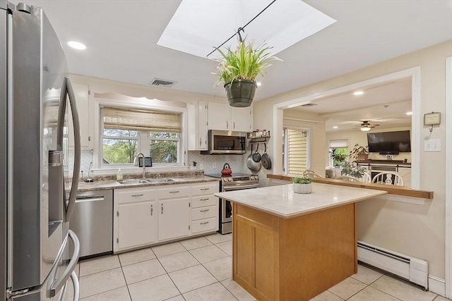 34 Woodland Cir, Methuen, MA 01844 - kitchen featuring stainless steel appliances, a baseboard radiator, a sink, light countertops, and backsplash