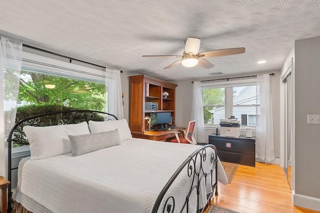 34 Woodland Cir, Methuen, MA 01844 - bedroom with light wood-type flooring, a textured ceiling, and a ceiling fan