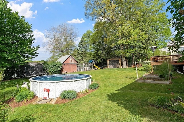 34 Woodland Cir, Methuen, MA 01844 - view of green lawn with a playground, a trampoline, an outdoor pool, a deck, and a garden