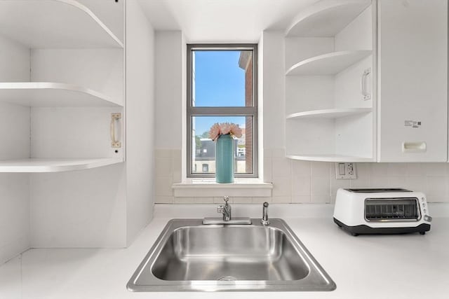 931 Massachusetts Ave Unit 606, Cambridge, MA 02139 - kitchen with open shelves, light countertops, white cabinetry, and backsplash