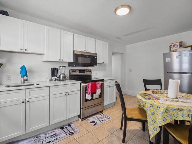 15-17 W Chestnut St, Brockton, MA 02301 - kitchen with stainless steel appliances, white cabinetry, light countertops, and light tile patterned flooring