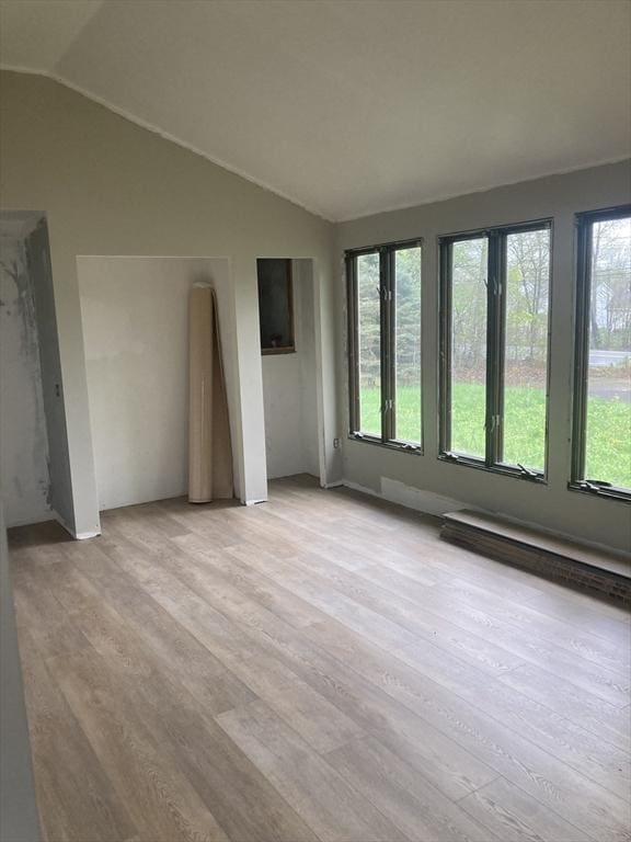 interior space with light wood-type flooring and vaulted ceiling
