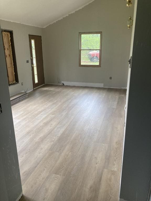 empty room with plenty of natural light, wood finished floors, and baseboards