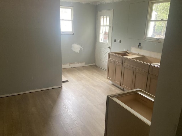 washroom with light wood finished floors, baseboards, and a sink