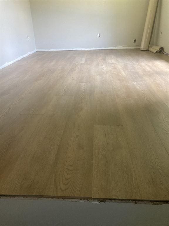 empty room featuring wood finished floors and baseboards