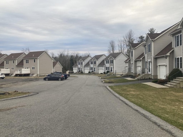 view of asphalt street featuring a residential view and curbs