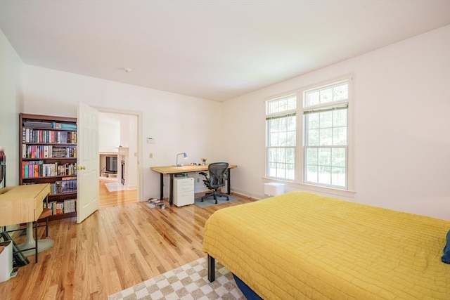 97 High Pine Cir Unit 97, Wilbraham, MA 01095 - bedroom with light wood-type flooring, a desk, a fireplace, and baseboards