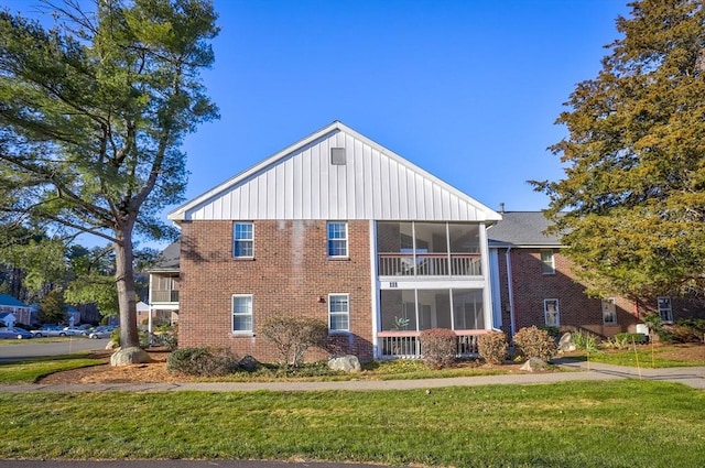 view of property exterior featuring a sunroom and a yard