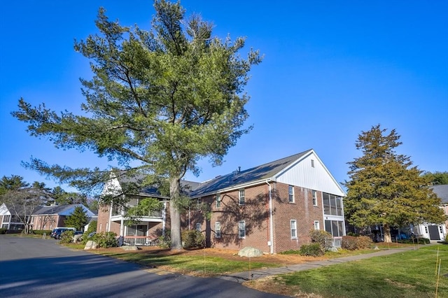 view of home's exterior featuring a balcony and a lawn