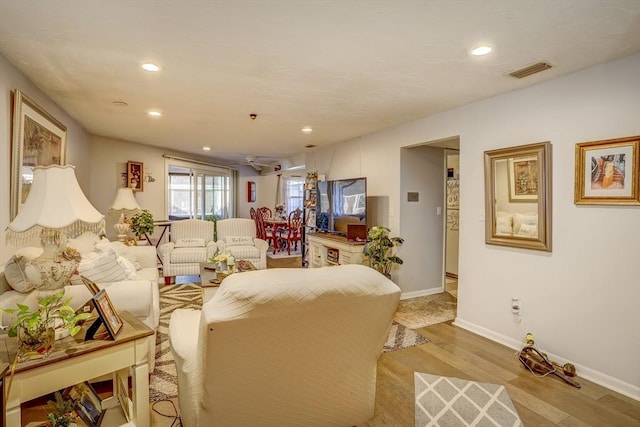 living room featuring light wood-type flooring and ceiling fan