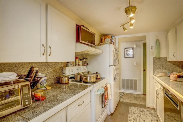 kitchen featuring backsplash, white cabinets, exhaust hood, and appliances with stainless steel finishes