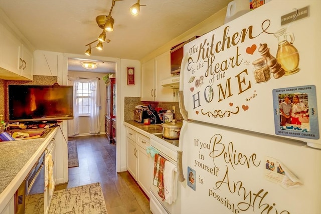 kitchen featuring rail lighting, light hardwood / wood-style floors, white appliances, white cabinets, and exhaust hood