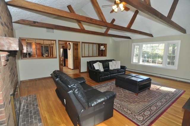 living area featuring ceiling fan, beam ceiling, and a baseboard heating unit