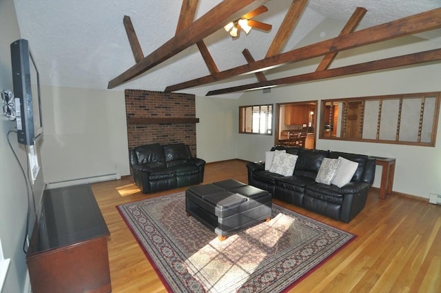 living area with lofted ceiling with beams, wood finished floors, a baseboard heating unit, a textured ceiling, and ceiling fan