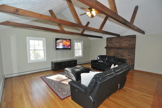 living room with a textured ceiling, light wood-style flooring, lofted ceiling with beams, and a baseboard heating unit