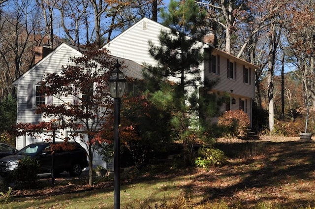 view of side of home featuring a garage and a chimney