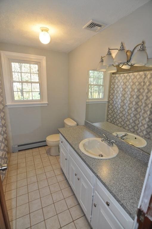 bathroom with tile patterned flooring, a wealth of natural light, a baseboard radiator, and visible vents