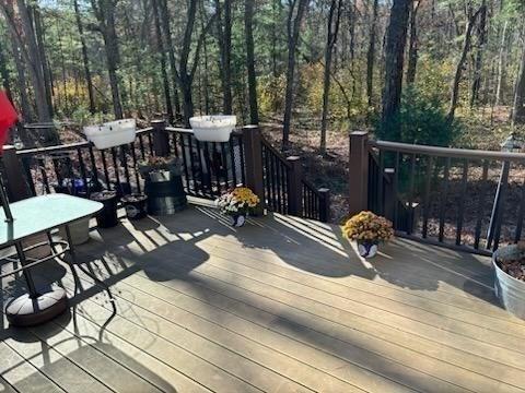 wooden deck with a wooded view