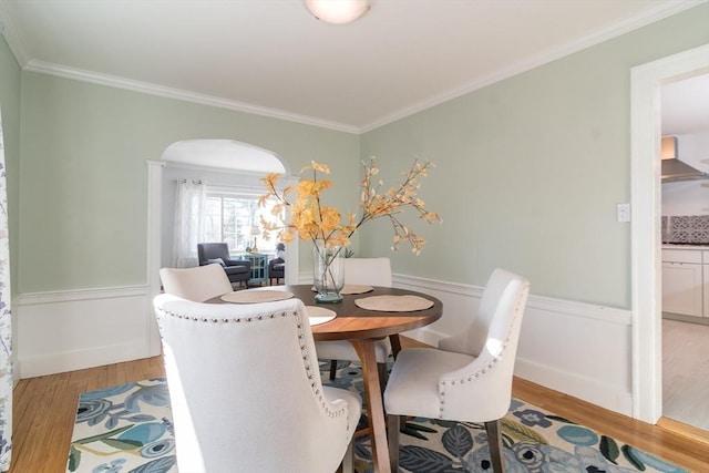 dining area with crown molding and light hardwood / wood-style floors