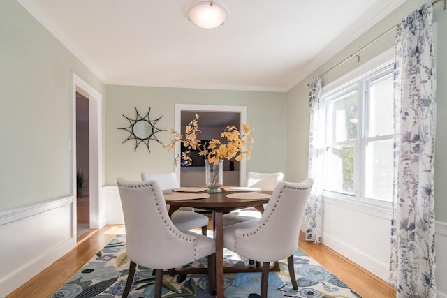 dining area with crown molding and light hardwood / wood-style flooring