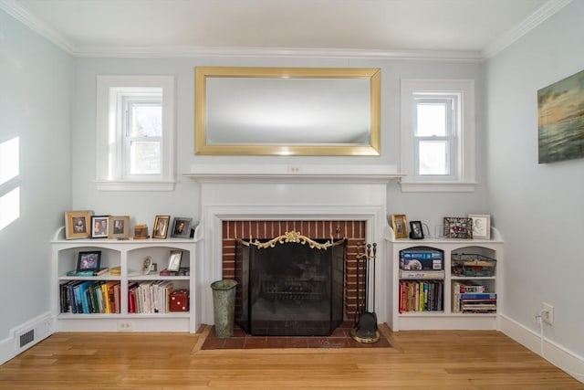 unfurnished room with a brick fireplace, crown molding, and wood-type flooring