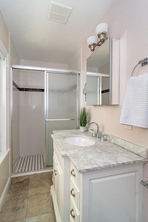 bathroom featuring vanity and a shower with shower door