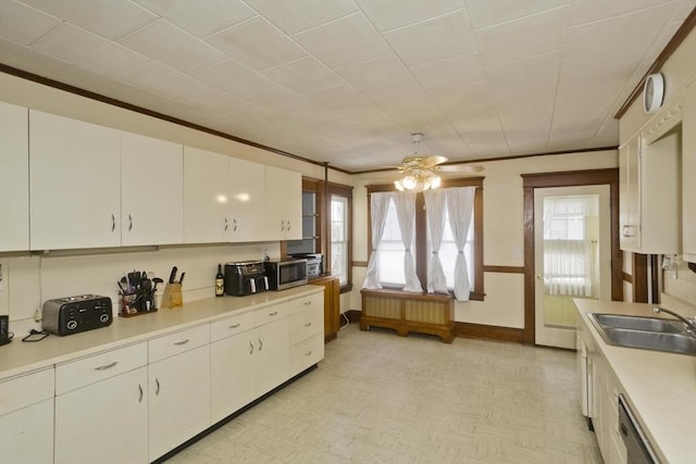 kitchen with light countertops, appliances with stainless steel finishes, a sink, and white cabinetry