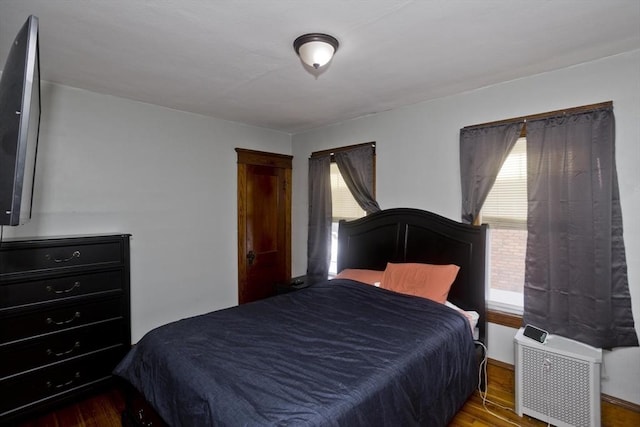 bedroom with radiator and wood finished floors