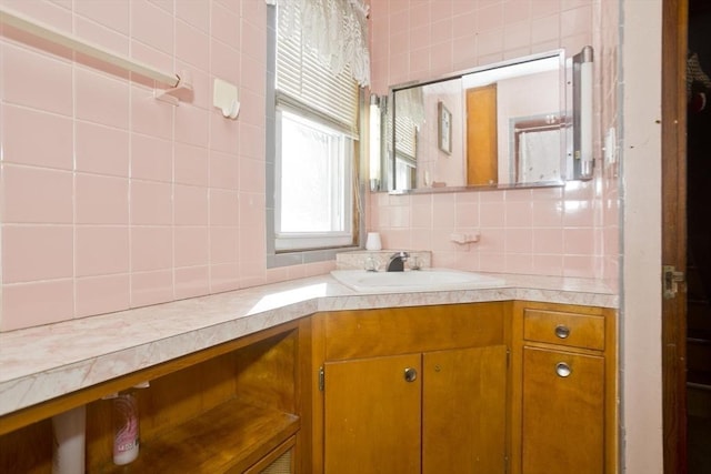 bathroom with tile walls, vanity, and decorative backsplash