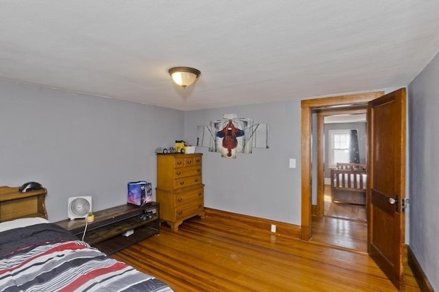 bedroom featuring baseboards and wood finished floors