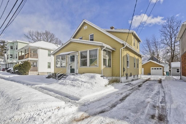 bungalow-style home with entry steps, a detached garage, and an outdoor structure