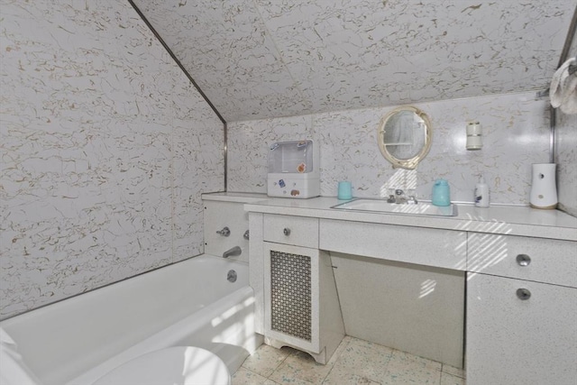 bathroom featuring lofted ceiling and vanity