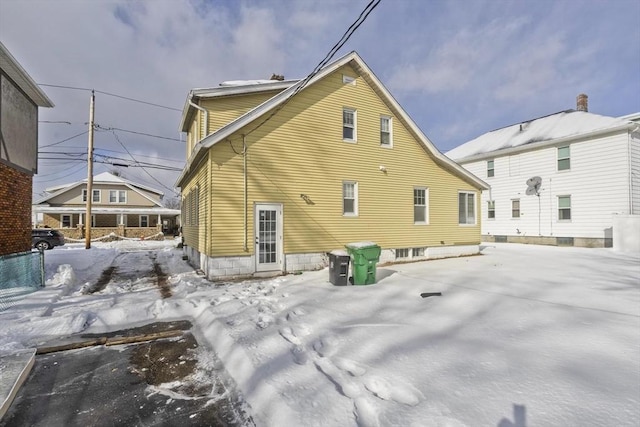 view of snow covered back of property