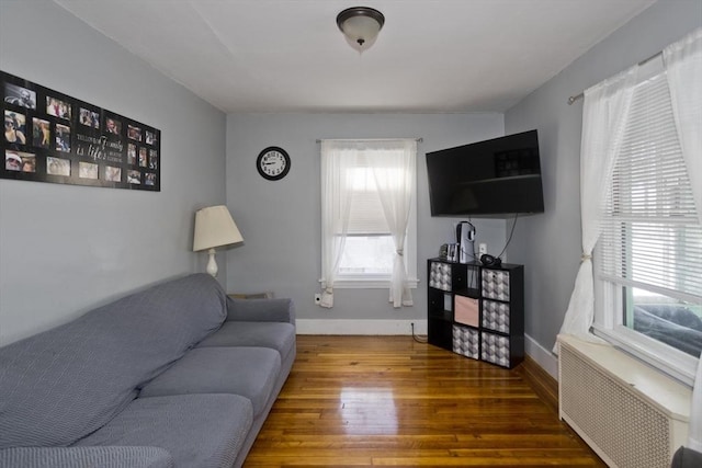 living area featuring baseboards, radiator heating unit, and wood finished floors