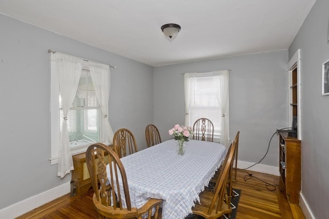 dining space featuring baseboards and wood finished floors