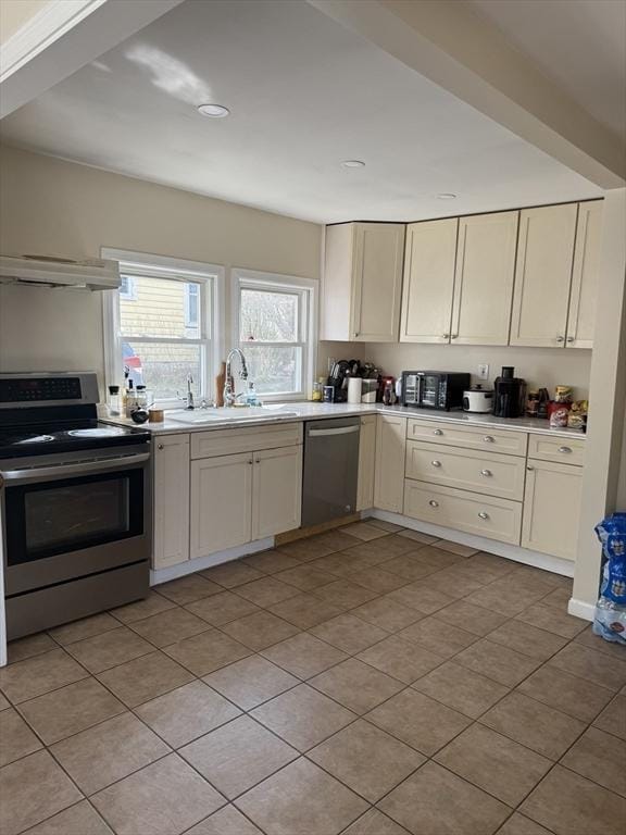 kitchen with a sink, stainless steel appliances, exhaust hood, light countertops, and light tile patterned floors