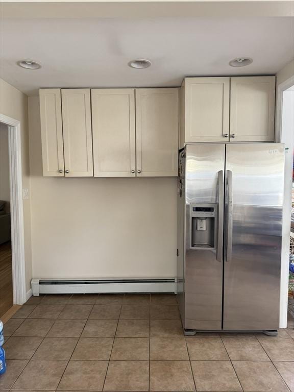 kitchen featuring light tile patterned floors, a baseboard radiator, and stainless steel fridge with ice dispenser