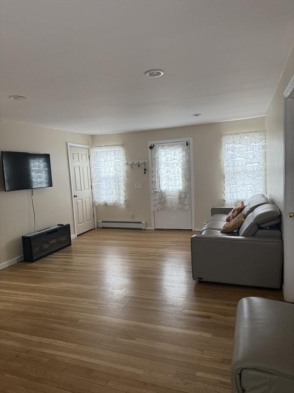 living room featuring a baseboard radiator and wood finished floors