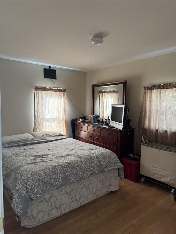 bedroom with crown molding and wood finished floors