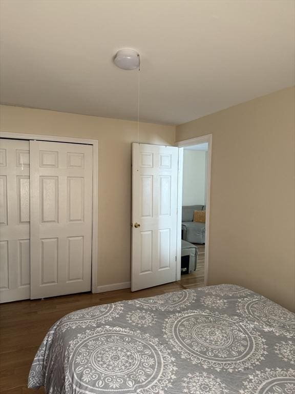 bedroom featuring a closet, baseboards, and wood finished floors