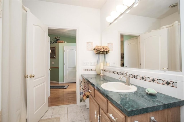 bathroom with tile patterned flooring, vanity, and decorative backsplash