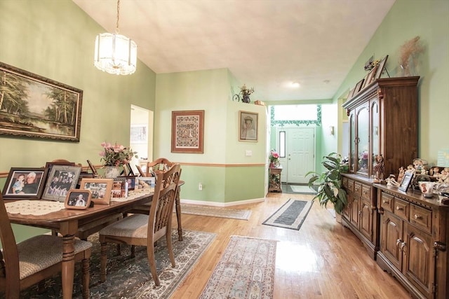 dining area featuring a chandelier, light wood-type flooring, and baseboards