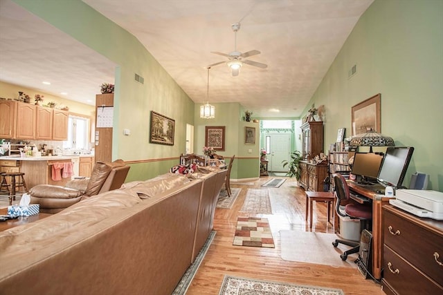 living room featuring light wood finished floors, ceiling fan, and visible vents