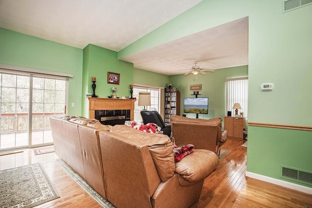 living room featuring light wood finished floors, a premium fireplace, and visible vents